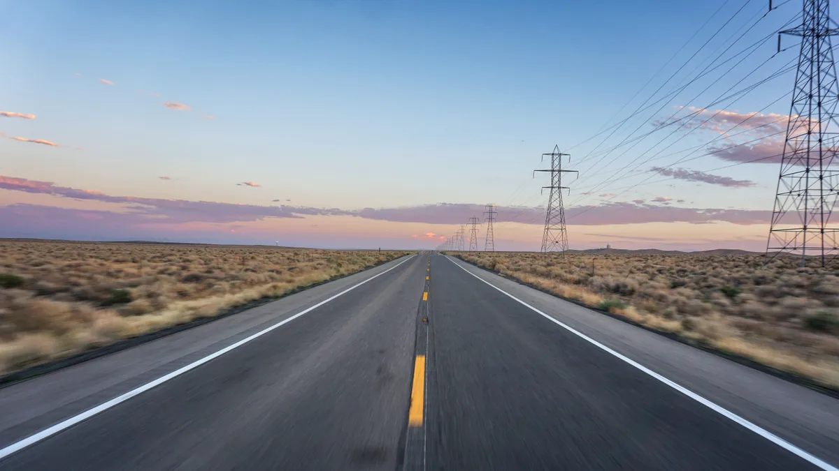 Electric transmission lines alongside a highway.