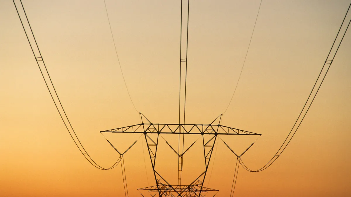 Pylon with power lines against reddish sky at sunset, rural North Carolina, USA.